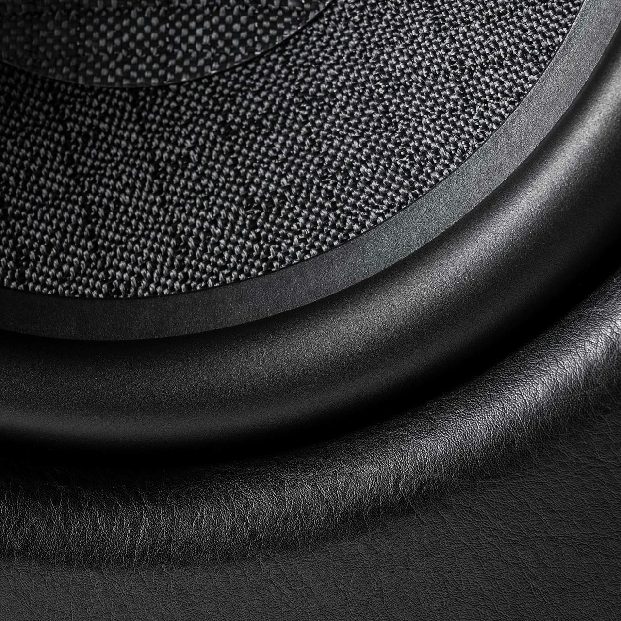 Detailed close-up of the Sonus faber Gravis VI subwoofer speaker, showcasing intricate details and emphasizing the luxurious black leather finish.