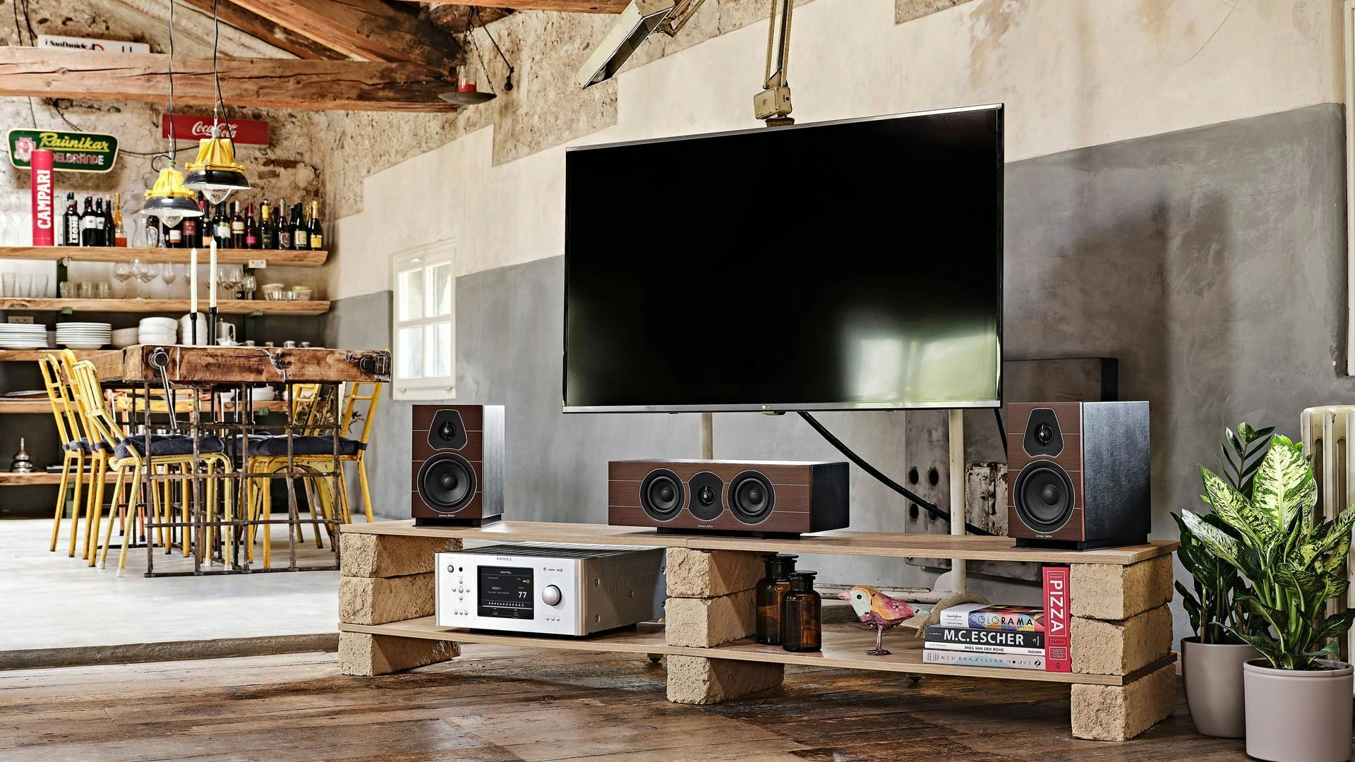 Sonus faber Lumina CI center channel speakers flanked by Lumina bookshelf speakers on a TV stand, creating a captivating home cinema setup.