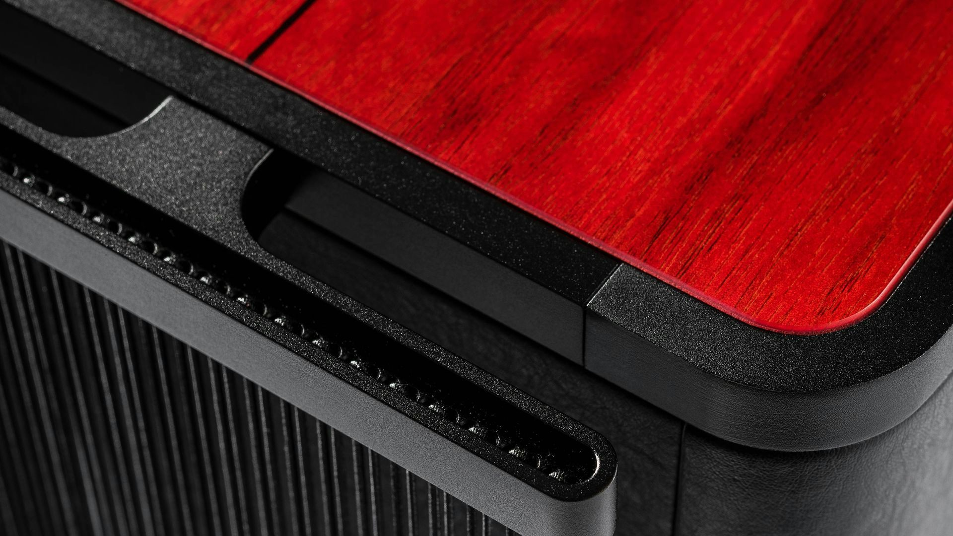 Close-up view of the Sonus faber Gravis VI subwoofer, highlighting the captivating red wood and black leather finish.