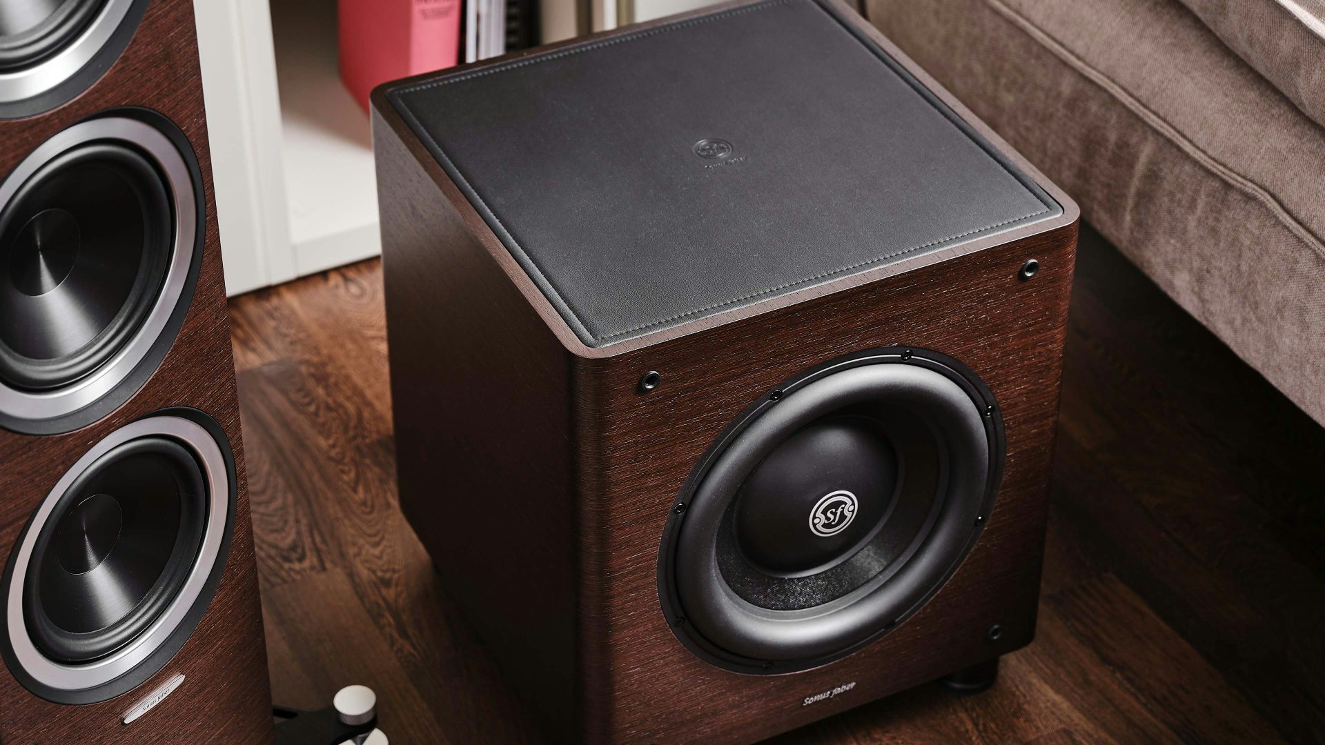 Sonus faber Gravis II subwoofer in wenge wood, black leather top, blending seamlessly with the surrounding colors in a stylish home.